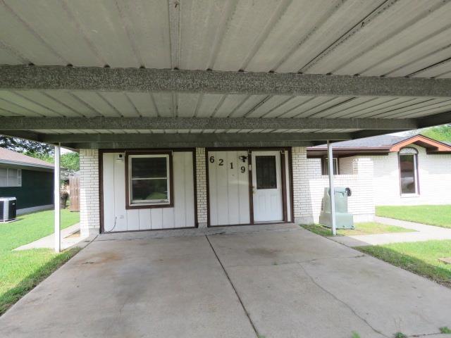 6219 16th St, Port Arthur, TX 77642 - exterior space with a front yard, brick siding, an attached carport, and cooling unit