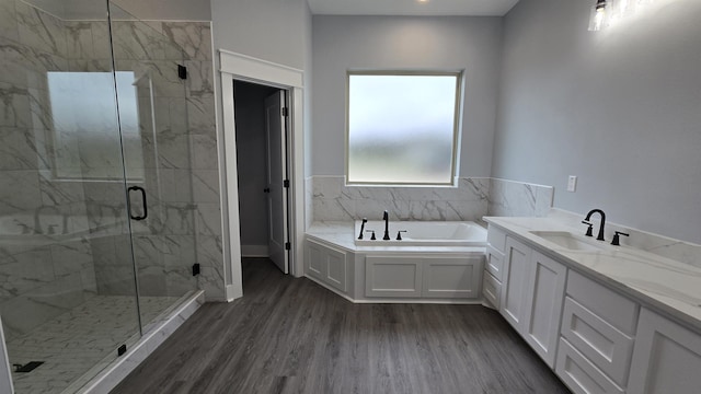 bathroom featuring hardwood / wood-style flooring, shower with separate bathtub, and vanity