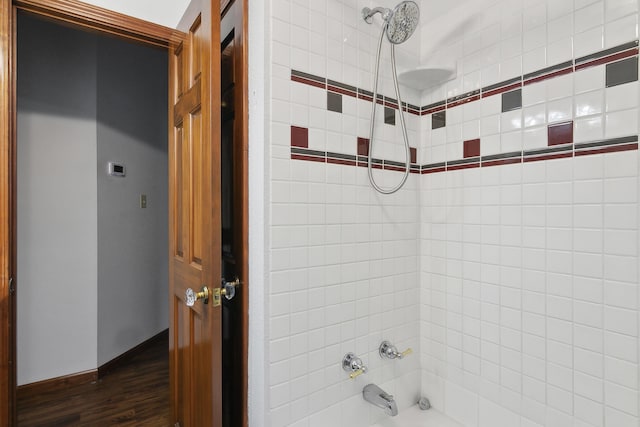 bathroom with tiled shower / bath combo and wood-type flooring