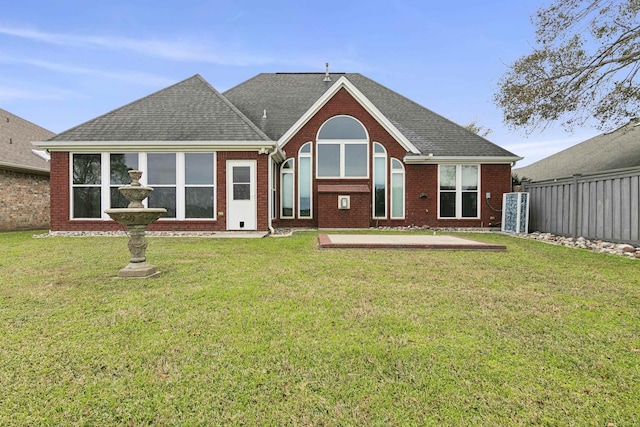 rear view of house featuring a lawn