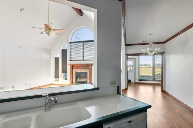 kitchen featuring ceiling fan with notable chandelier, sink, wood-type flooring, high vaulted ceiling, and dishwasher