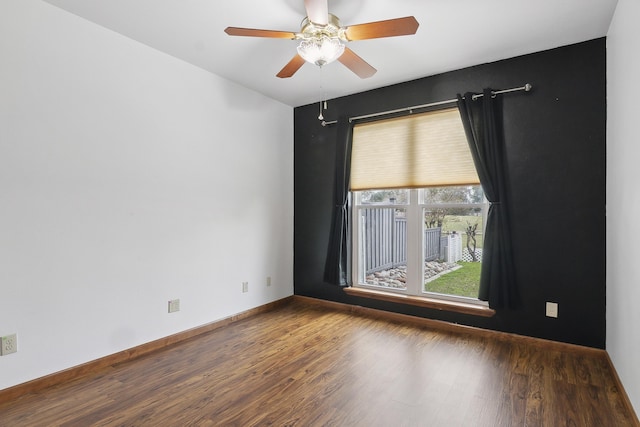 empty room with ceiling fan and dark hardwood / wood-style flooring