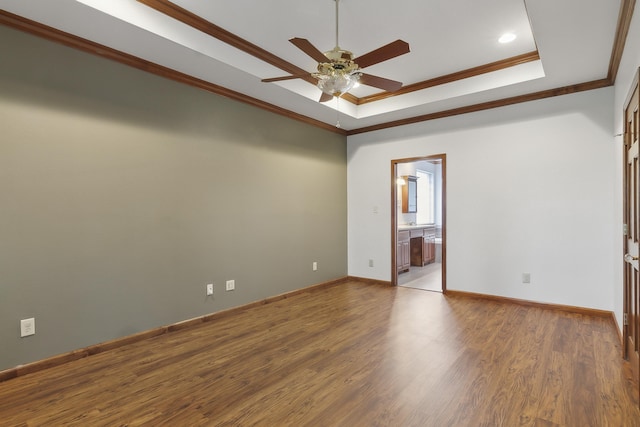 empty room featuring ceiling fan, light hardwood / wood-style flooring, crown molding, and a tray ceiling