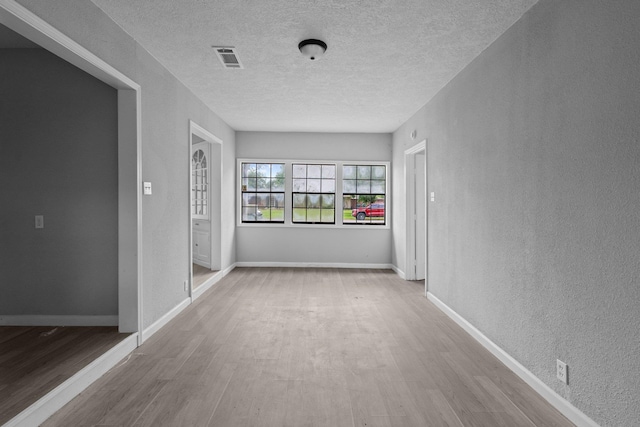 3015 Timberwood Ln, Beaumont, TX 77703 - spare room with wood finished floors, a textured wall, a textured ceiling, and baseboards