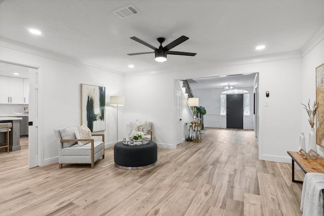 sitting room with ceiling fan, crown molding, and light hardwood / wood-style flooring