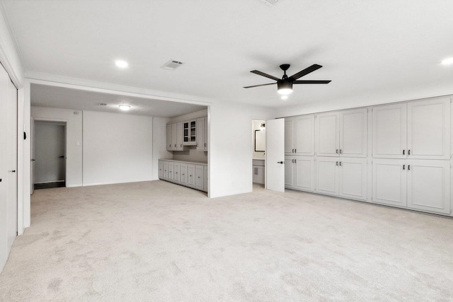 unfurnished bedroom with connected bathroom, ceiling fan, and light colored carpet