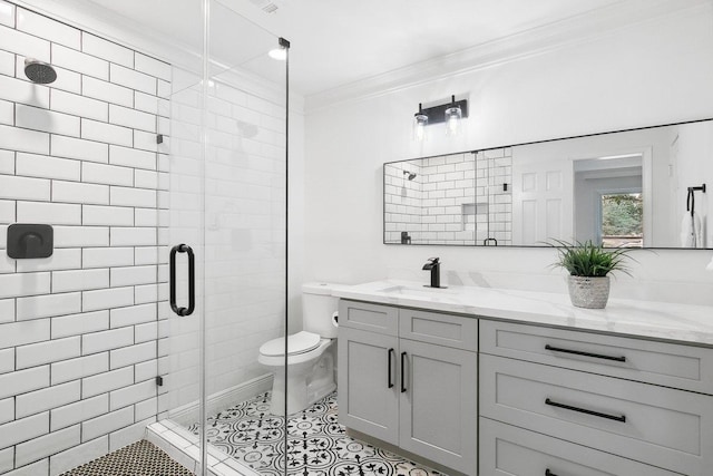 bathroom with tile patterned flooring, toilet, a shower with door, vanity, and ornamental molding