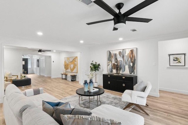 living room with ceiling fan, ornamental molding, and hardwood / wood-style flooring