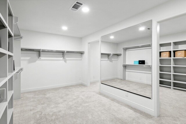 walk in closet featuring light carpet