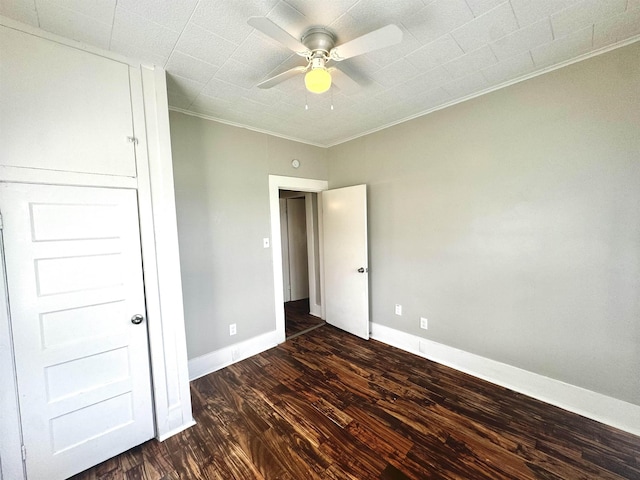 unfurnished bedroom with dark wood-type flooring, ceiling fan, and crown molding