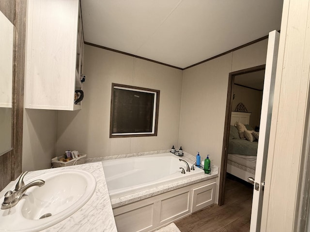 ensuite bathroom featuring a bath, ensuite bathroom, crown molding, and a sink