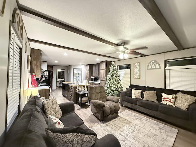 living room with recessed lighting, ceiling fan, a textured ceiling, beamed ceiling, and light wood-type flooring