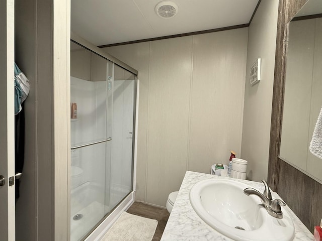 full bathroom featuring vanity, wood finished floors, visible vents, a stall shower, and toilet