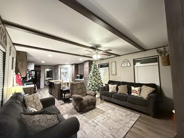 living area with light wood-type flooring, beam ceiling, a ceiling fan, a textured ceiling, and recessed lighting