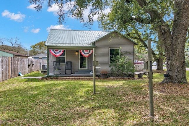 bungalow-style home featuring central air condition unit, covered porch, and a front yard