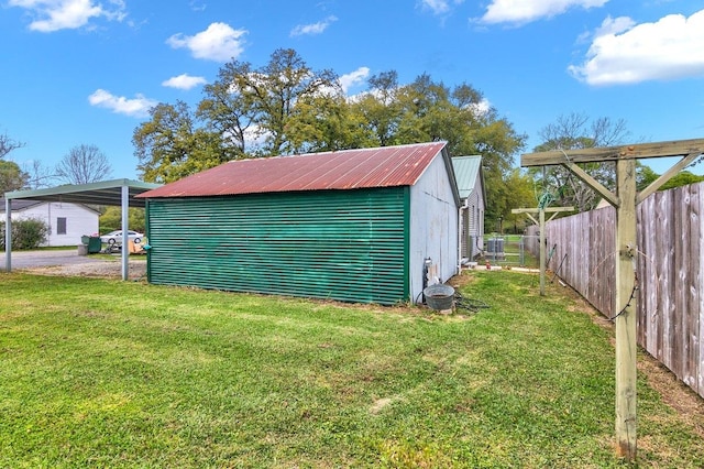 view of outdoor structure with a yard and a carport