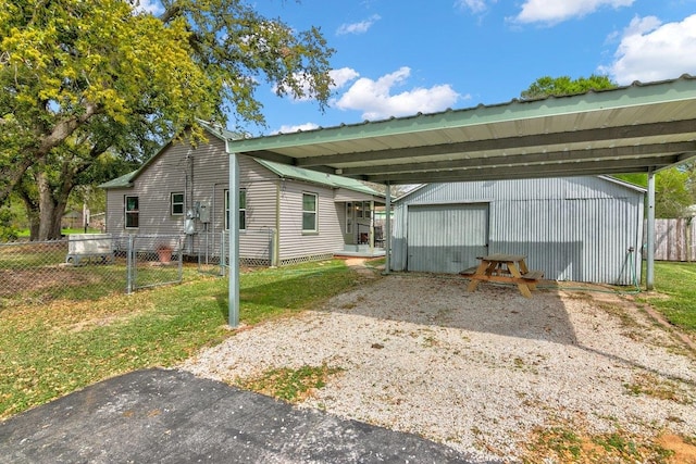 back of property with an outdoor structure and a carport