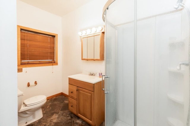 bathroom featuring vanity, toilet, and a shower with shower door