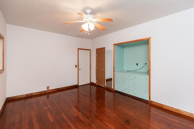 unfurnished bedroom featuring dark hardwood / wood-style flooring, a textured ceiling, and ceiling fan