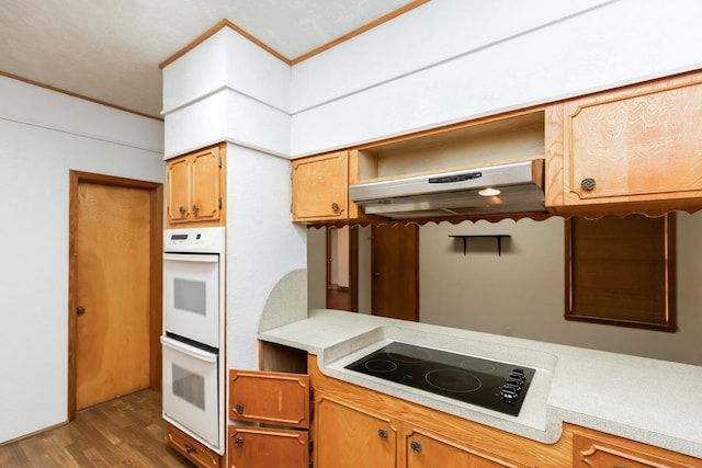 kitchen featuring electric cooktop, dark hardwood / wood-style floors, and white double oven