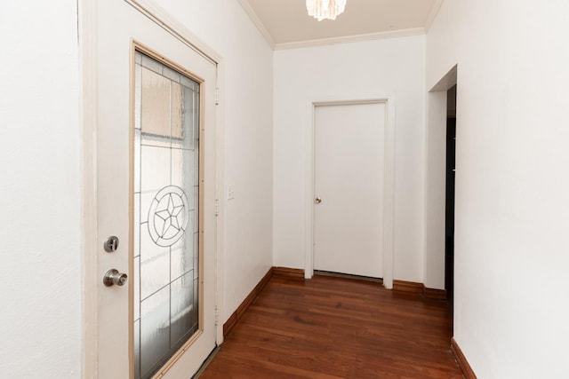 hallway featuring ornamental molding, a notable chandelier, and dark hardwood / wood-style flooring