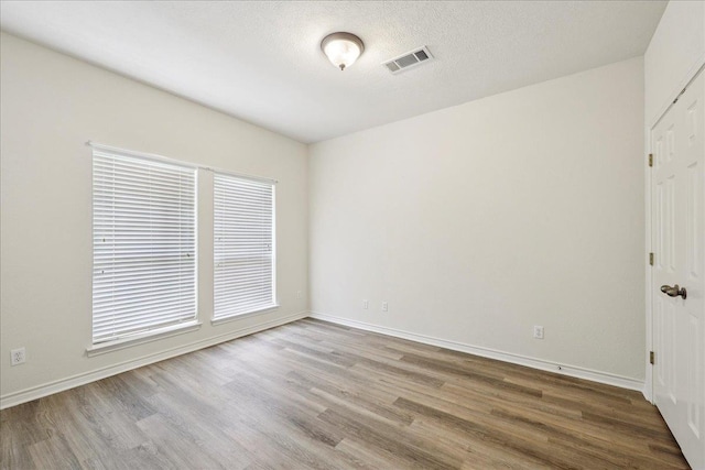 8076 Indian Blanket Dr, Beaumont, TX 77713 - spare room with wood finished floors, plenty of natural light, and a textured ceiling