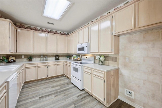 8076 Indian Blanket Dr, Beaumont, TX 77713 - kitchen featuring white appliances, light brown cabinetry, light countertops, light wood-style flooring, and backsplash