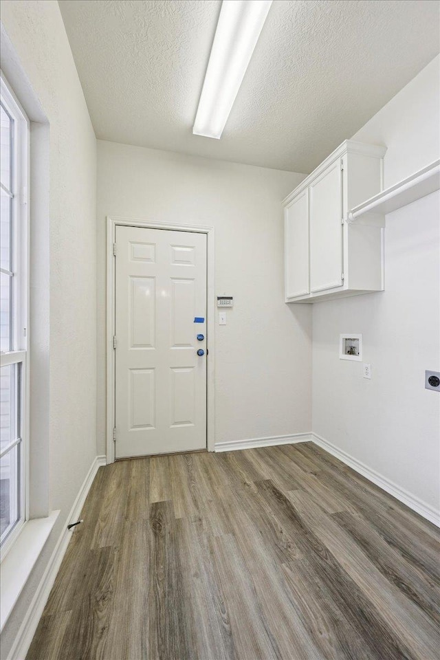 8076 Indian Blanket Dr, Beaumont, TX 77713 - washroom with cabinet space, wood finished floors, electric dryer hookup, washer hookup, and a textured ceiling