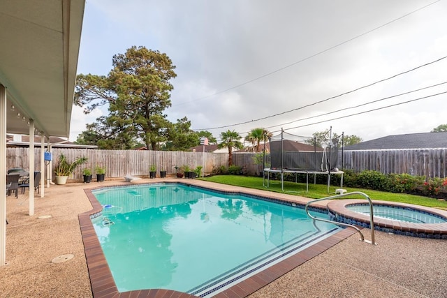915 S 23rd St, Nederland, TX 77627 - view of swimming pool featuring a trampoline, a pool with connected hot tub, and a fenced backyard
