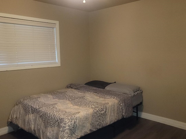 bedroom with dark wood-type flooring