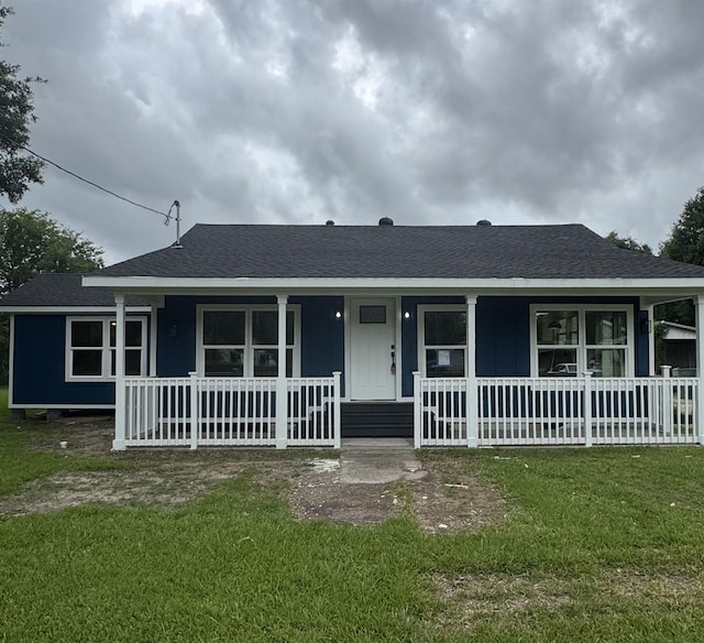 3128 58th St, Port Arthur, TX 77640 - view of front facade featuring covered porch, a shingled roof, and a front lawn