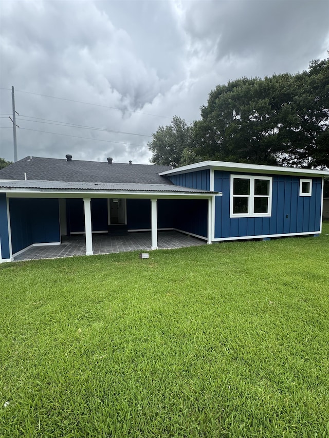 3128 58th St, Port Arthur, TX 77640 - rear view of house featuring board and batten siding and a lawn