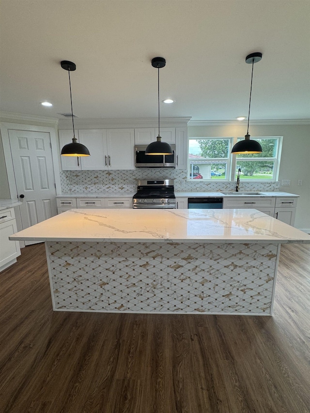 3128 58th St, Port Arthur, TX 77640 - kitchen with stainless steel range with gas stovetop, dark wood-type flooring, white cabinetry, tasteful backsplash, and ornamental molding