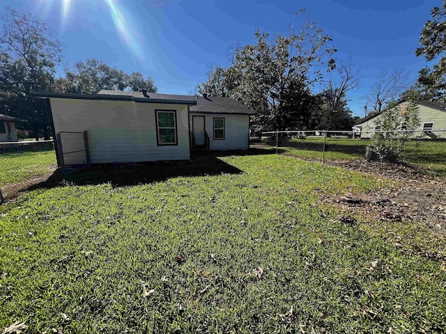 back of house featuring a lawn