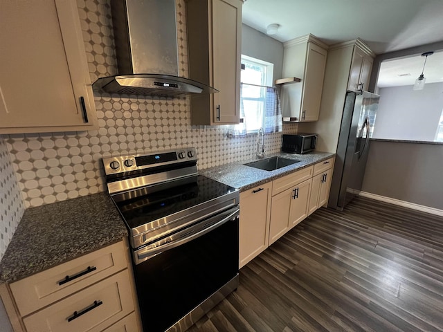 kitchen with sink, wall chimney exhaust hood, dark hardwood / wood-style floors, dark stone counters, and appliances with stainless steel finishes