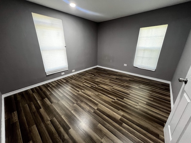 unfurnished room with dark wood-type flooring