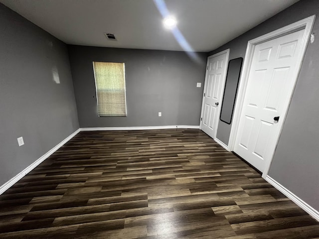 unfurnished bedroom with dark hardwood / wood-style floors