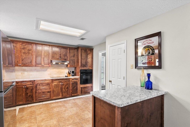 kitchen with black appliances, backsplash, and a textured ceiling