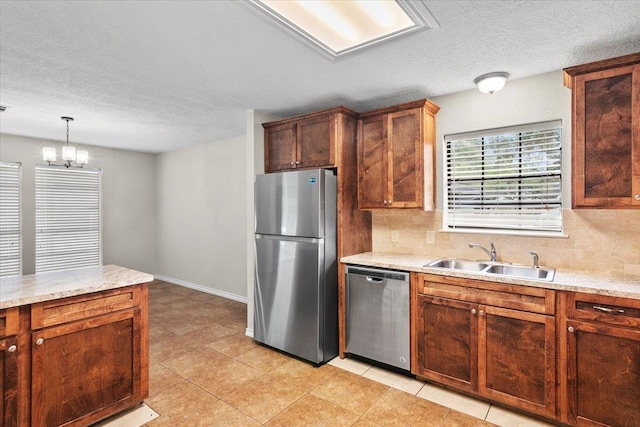 kitchen with pendant lighting, an inviting chandelier, sink, light tile patterned floors, and appliances with stainless steel finishes