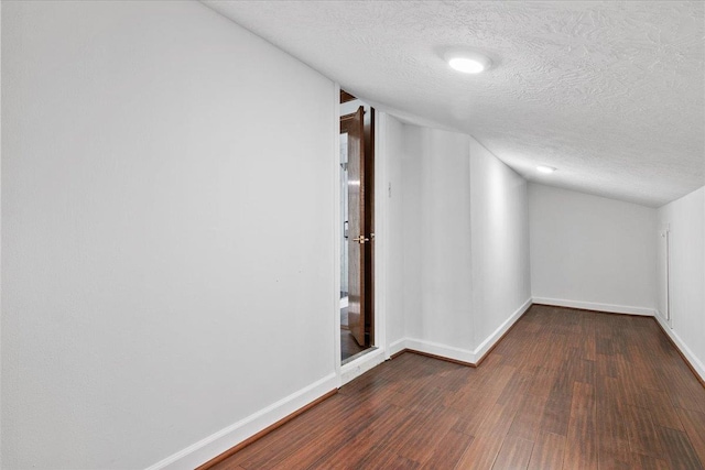 bonus room featuring a textured ceiling, dark hardwood / wood-style floors, and vaulted ceiling