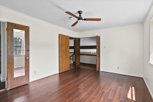 unfurnished bedroom featuring a textured ceiling, dark hardwood / wood-style flooring, and ceiling fan