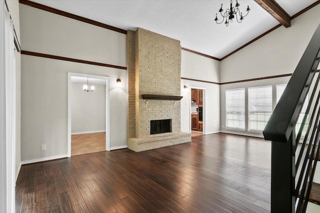 unfurnished living room featuring lofted ceiling with beams, a stone fireplace, wood-type flooring, and an inviting chandelier