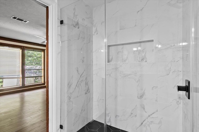 bathroom featuring an enclosed shower and a textured ceiling