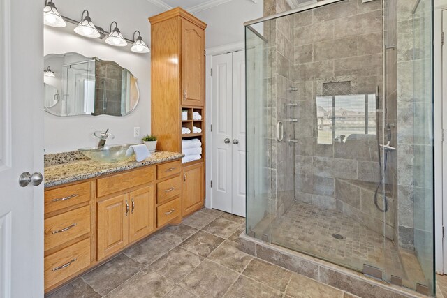 bathroom featuring vanity, a shower with door, and crown molding