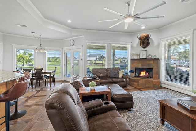 living room featuring ceiling fan, ornamental molding, and a fireplace