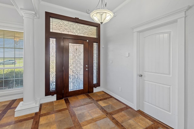 entrance foyer featuring decorative columns and ornamental molding