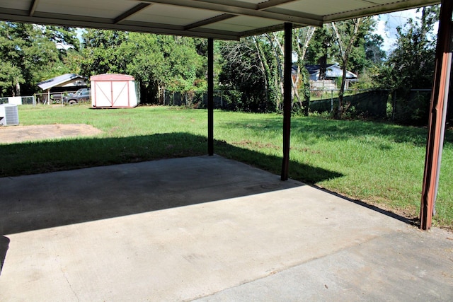 view of patio with central AC unit and a shed