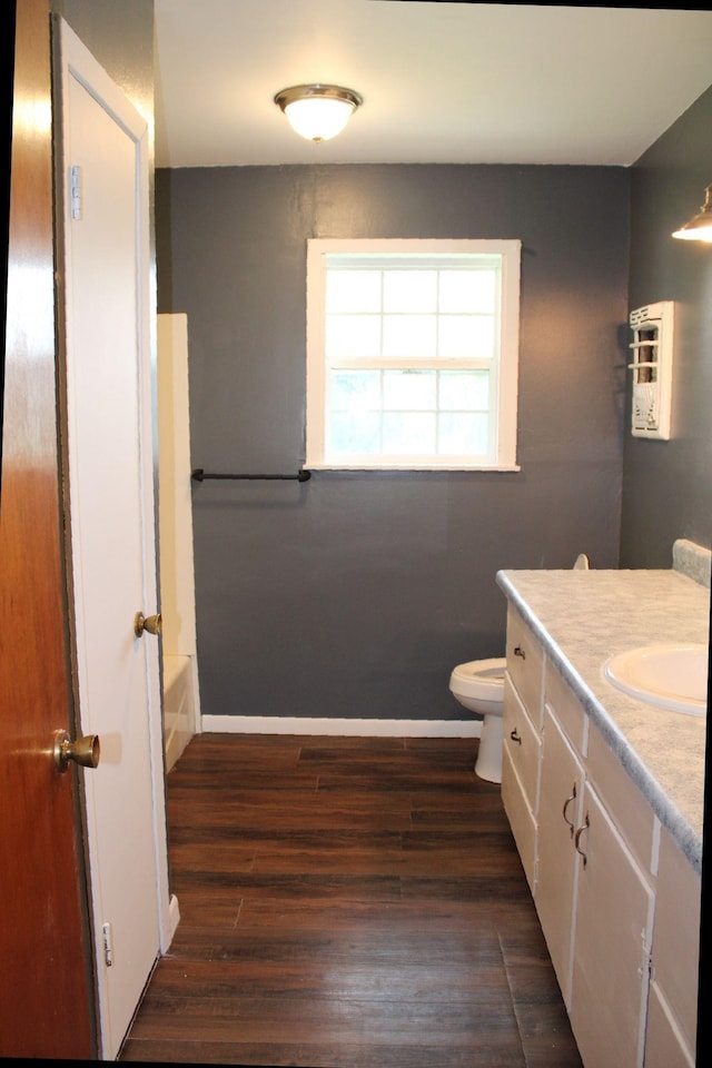 bathroom with vanity, toilet, wood-type flooring, and a washtub