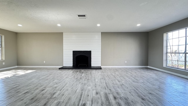 674 Ridgewood Dr, Port Neches, TX 77651 - unfurnished living room featuring plenty of natural light, wood finished floors, baseboards, a textured ceiling, and recessed lighting