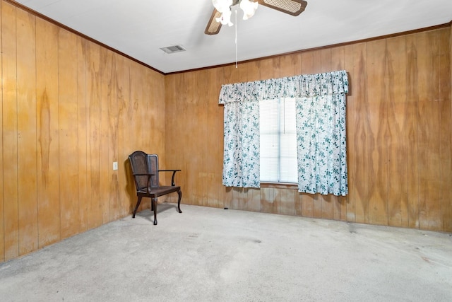 unfurnished room with light carpet, ceiling fan, and wood walls